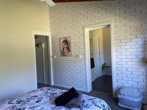 a bedroom with a white brick wall and a bed at Close to Coast & Bellarine Peninsula in Moolap