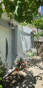 a patio with a table and a chair and flowers at Apartman Annamaria in Cres