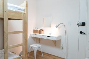 ソウルにあるThe Blossom Yeonnam Guesthouseのベッドルーム1室(二段ベッド1組、鏡付きデスク付)