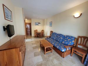 a living room with a couch and a tv at Torres Gardens-Fincas Benidorm in Benidorm