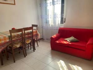 salon z czerwoną kanapą i stołem w obiekcie la casa di Ste' w Mediolanie