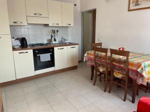 a kitchen with white cabinets and a table with chairs at la casa di Ste' in Milan +7 photos