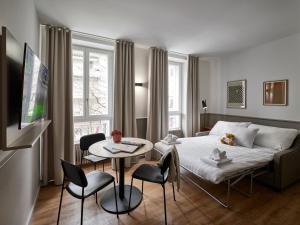 - une chambre avec un lit, une table et des chaises dans l'établissement Base Lausanne, à Lausanne