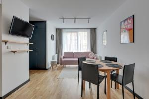 a living room with a table and a couch at Downtown Apartments Dwie Motławy Riverside & Parking in Gdańsk