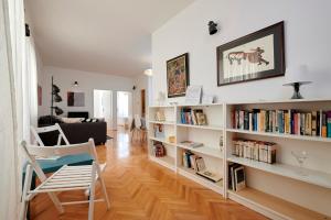 ein Wohnzimmer mit weißen Bücherregalen mit Büchern in der Unterkunft Apartment Tin in Trogir