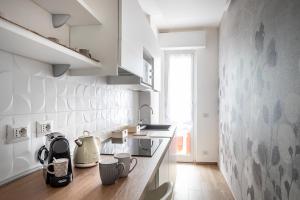 a kitchen with white walls and a wooden counter top at A Casa di Ale in Cinisello Balsamo