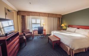 伊魁特的住宿－弗羅比舍酒店，配有一张床和一台平面电视的酒店客房