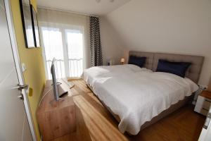 a bedroom with a white bed and a window at Ferienhaus Anni in Puddemin