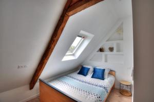 um quarto com um banco com almofadas azuis em Rêves Bleus - Côte de Granit Rose em Ploubezre
