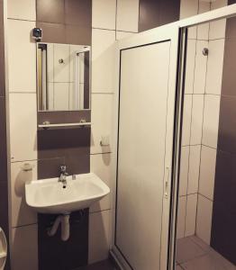 a white bathroom with a sink and a shower at Къща за гости Kita in Sveti Vlas
