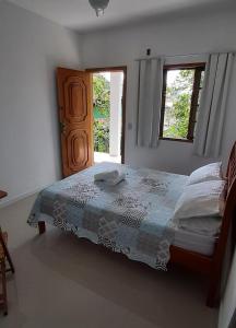 a bedroom with a bed and two windows at Ilha Suites - Vila do Abraão in Abraão