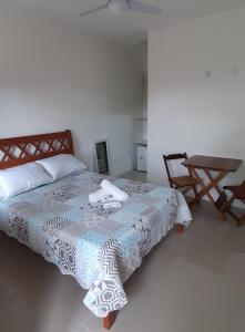a bedroom with a bed and a table and chairs at Ilha Suites - Vila do Abraão in Abraão