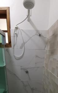 Ilha Suites - Vila do Abraão في أبراو: حمام مع دش مع مرآة على الحائط