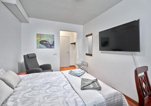 Un dormitorio con una cama y un televisor de pantalla plana. en Hotelli-Ravintola Gasthaus Lohja, en Lohja