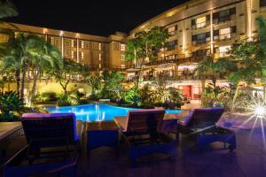 ein Hotel mit Stühlen und einem Swimmingpool in der Nacht in der Unterkunft Kigali Serena Hotel in Kigali