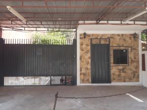 a building with a black gate and a fence at Habitación en casa zona Asunción in Asunción