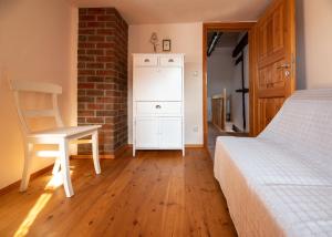 a bedroom with a bed and a chair and a brick wall at Historisches Fischerhäuschen in Ribnitz-Damgarten