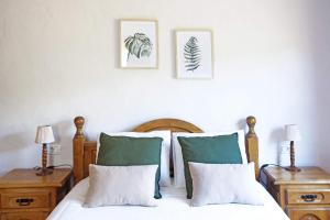 a bedroom with a bed with green and white pillows at Casa El Colmenero in Garafía +31 photos