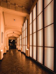 un couloir vide avec de grandes fenêtres dans un bâtiment dans l'établissement Harmon House, à Bruxelles