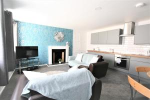 
a living room with a couch and a chair at Central Serviced Apartments by Roomsbooked in Cheltenham
