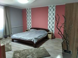 a bedroom with a bed and a pink wall at Tatabánya Újvárosi lakás in Tatabánya