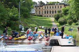 un grupo de personas de pie junto a barcos en un río en STF Lillsved, en Värmdö