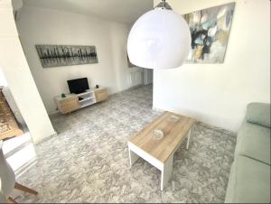 ein Wohnzimmer mit Tisch und Couch in der Unterkunft Apartamento Marbella centro con piscina in Marbella