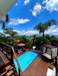 balcón con piscina en una terraza de madera en Pousada Altos do Rei en Praia do Rosa