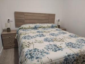 1 dormitorio con 1 cama con colcha de flores en La Portela Riverside, en Redondela
