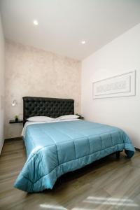 a bedroom with a bed with a blue blanket at Hotel Bruman Salerno in Salerno