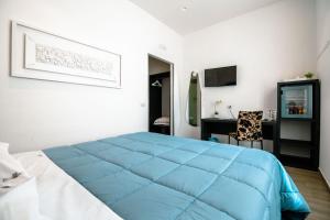 1 dormitorio con cama azul y escritorio en Hotel Bruman Salerno, en Salerno