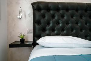 Bett mit einem schwarzen Kopfteil und einem Beistelltisch in der Unterkunft Hotel Bruman Salerno in Salerno