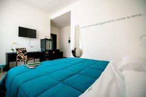 1 dormitorio con 1 cama azul grande y escritorio en Hotel Bruman Salerno, en Salerno