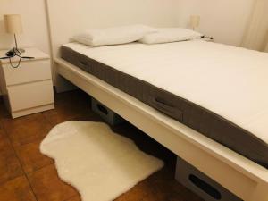 a bed in a room with a white bed frame and a rug at We Love Home Rome in Rome