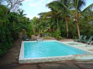 a swimming pool with chairs and palm trees at Sunset Bay Club & SeaSide Resort in Salisbury