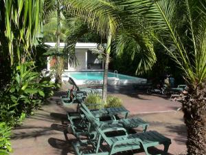 a group of green lounge chairs next to a swimming pool at Sunset Bay Club & SeaSide Dive Resort in Salisbury