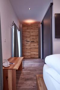 a bedroom with a wooden desk and a closet at Auberge Passepartout in Zeihen