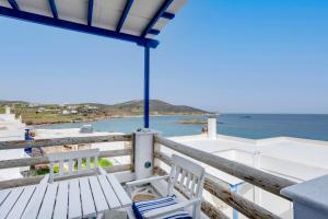 een balkon met twee witte stoelen en de oceaan bij ENDLESS BLUE from Syros - Fabrika Resort in Vári