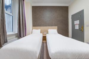 two beds sitting next to each other in a room at OYO 24 Sussex, London Paddington in London