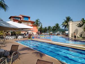 ein Pool in einem Resort mit einer neben ihm stehenden Person in der Unterkunft PORTO MARINA MONT BLANC RESORT in Mangaratiba