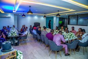 a group of people sitting at tables in a room at HIS Dulce Apartments in Lagos