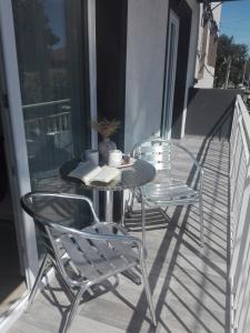 2 sillas y una mesa en un balcón con un libro en Bahía Pellegrini en Tandil