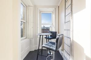 uma pequena mesa e duas cadeiras num quarto com uma janela em Beautiful 2 to 3 bed apartment with stunning views! em Ayr