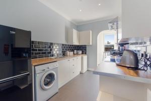 eine Küche mit Waschmaschine und Trockner in der Unterkunft Beautiful 2 to 3 bed apartment with stunning views! in Ayr
