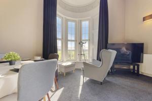 sala de estar con sillas, mesa y TV en Beautiful 2 to 3 bed apartment with stunning views!, en Ayr