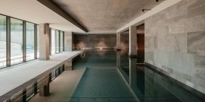 a swimming pool with green water in a building at VacationClub - Armii Krajowej Apartament 10 in Kołobrzeg
