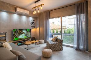 a living room with a couch and a tv at Lepanto Luxury Apartments FF in Nafpaktos