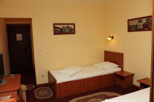 a small bedroom with a bed and a television at HOTEL T23 srl in Iaşi