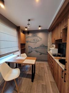 a kitchen with a desk and a table and chairs at Апартаменты на Титова in Dnipro