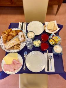 une table bleue avec des assiettes de nourriture et de pain dans l'établissement Villa Catelli, à Lucques 14 autres photos